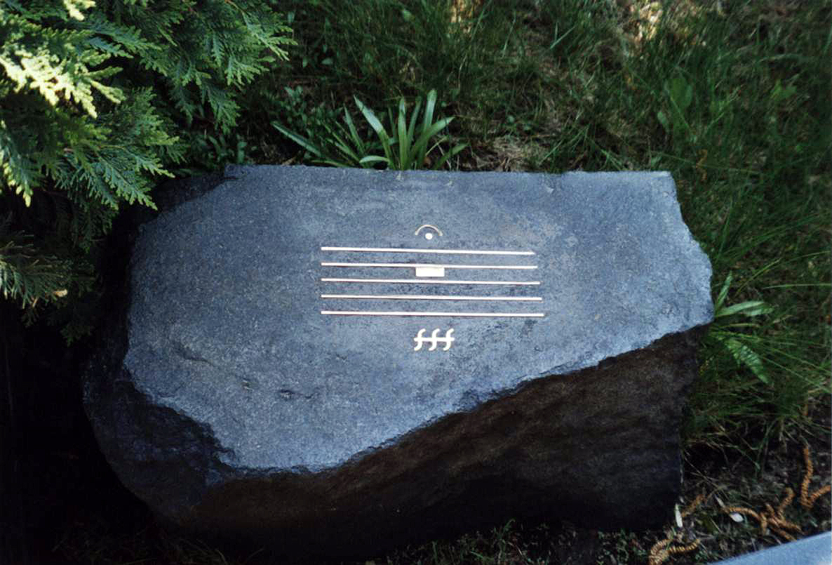 An image of SChnittke's Grave, showing a musical score, with a rest, fermata over the rest, and fff dynamic