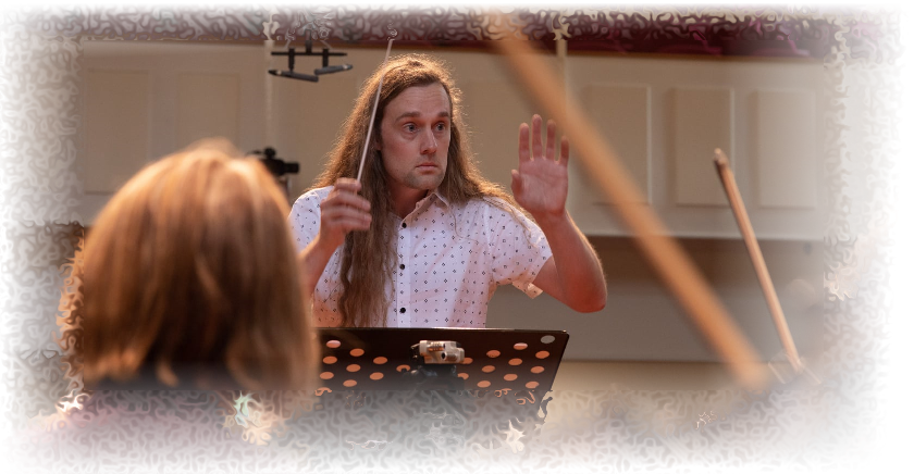 A picture of Tom conducting a string orchestra